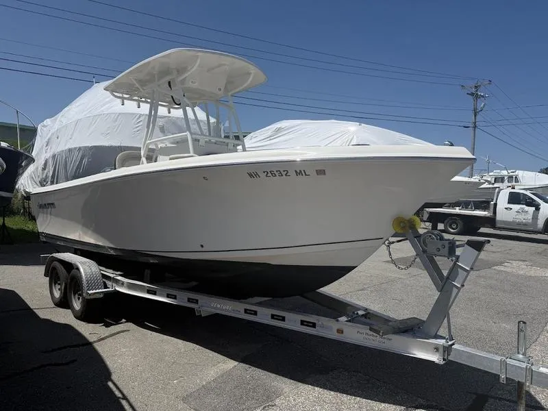 Slide: The Image of 2023 Sailfish 220 boat on trailer, covered, parked outdoors under clear sky. - 9