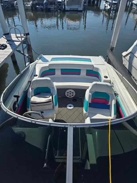 Slide: The Image of 1996 Formula 232 LS boat interior with colorful seating at a marina. - 6