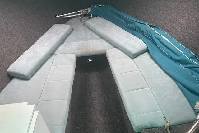 Slide: The Image of Interior of a 1996 Formula 232 LS boat with cushioned seating and blue cover. - 8