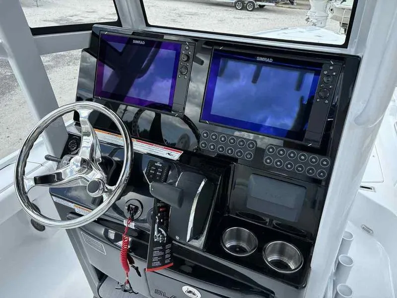 Slide: The Image of 2026 Blazer 2440 boat dashboard with dual Simrad displays and steering wheel. - 18