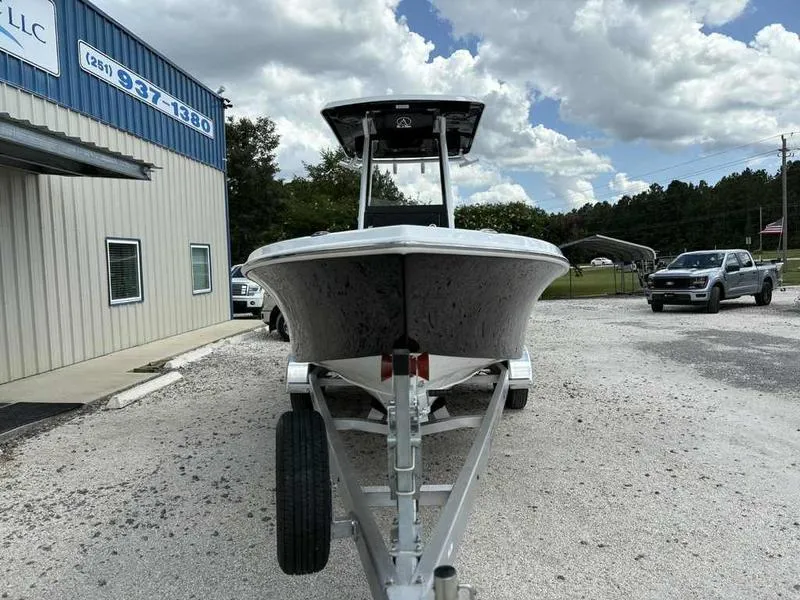 Slide: The Image of 2026 Blazer 2440 boat on trailer outside dealership under cloudy sky. - 2