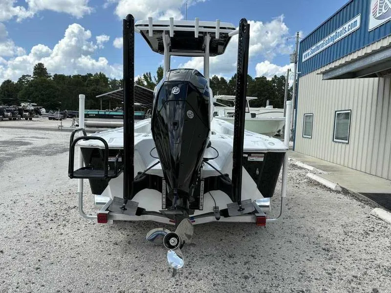 Slide: The Image of 2026 Blazer 2440 boat with outboard motor, parked outside a marine dealership. - 3