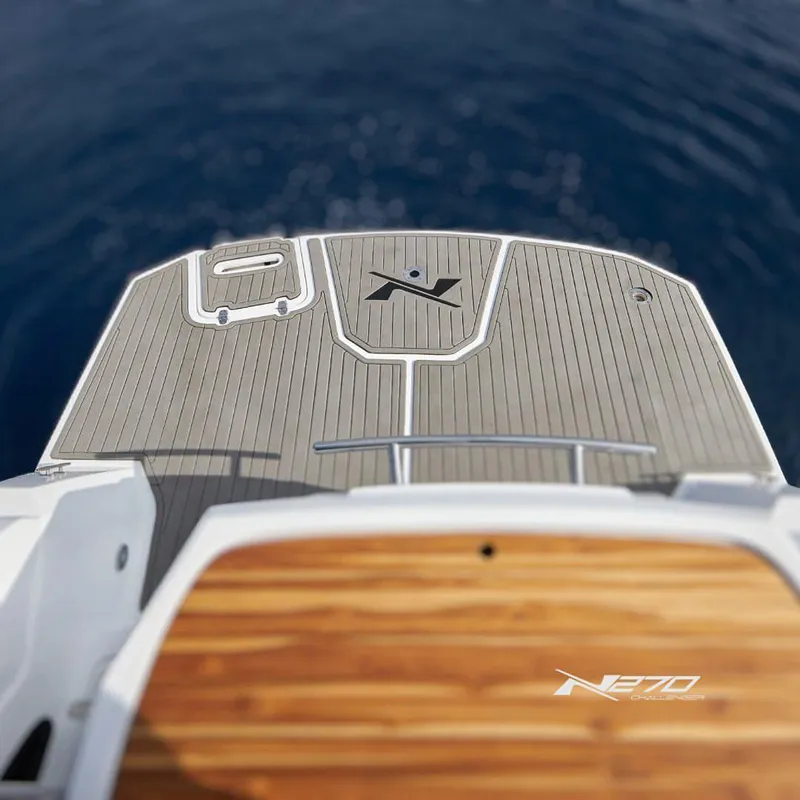 Slide: The Image of 2025 NX Boats NX270 Challenger deck with sleek design on calm water. - 5