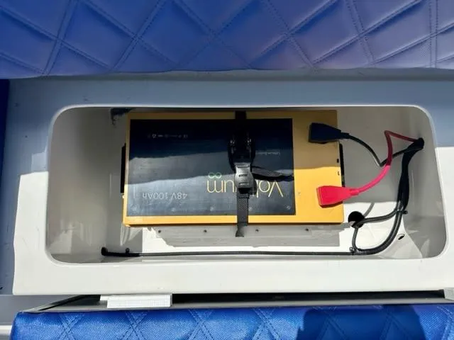 Slide: The Image of 2024 Vision Marine Technologies Fantail 217 battery compartment with lithium battery and wiring. - 13