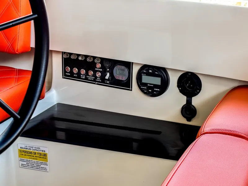 Slide: The Image of 2024 Vision Marine Fantail 217 dashboard with controls, red seating, and capacity label. - 5