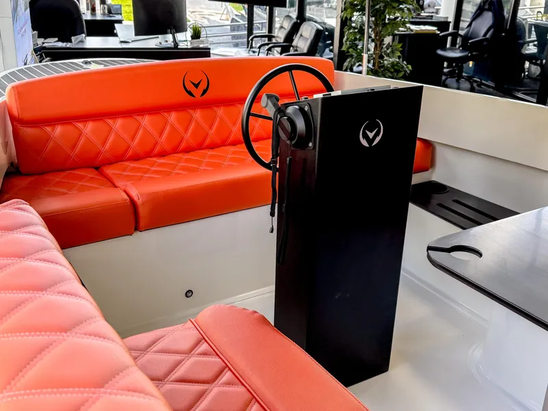 Slide: The Image of 2024 Vision Marine Technologies Fantail 217 interior with orange seating and steering console. - 9