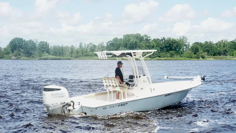 The Image of 2018 Key West 230 Bay Reef boat cruising on a lake with lush green shoreline. - 0