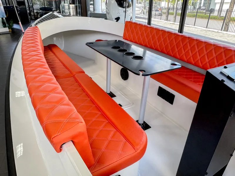 Slide: The Image of 2024 Vision Marine Technologies Fantail 217 boat interior with orange seating and a central table. - 6