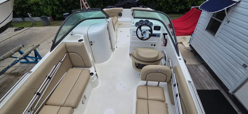 Slide: The Image of 2019 NauticStar 223DC Sport Deck boat with beige seating and modern dashboard. - 13