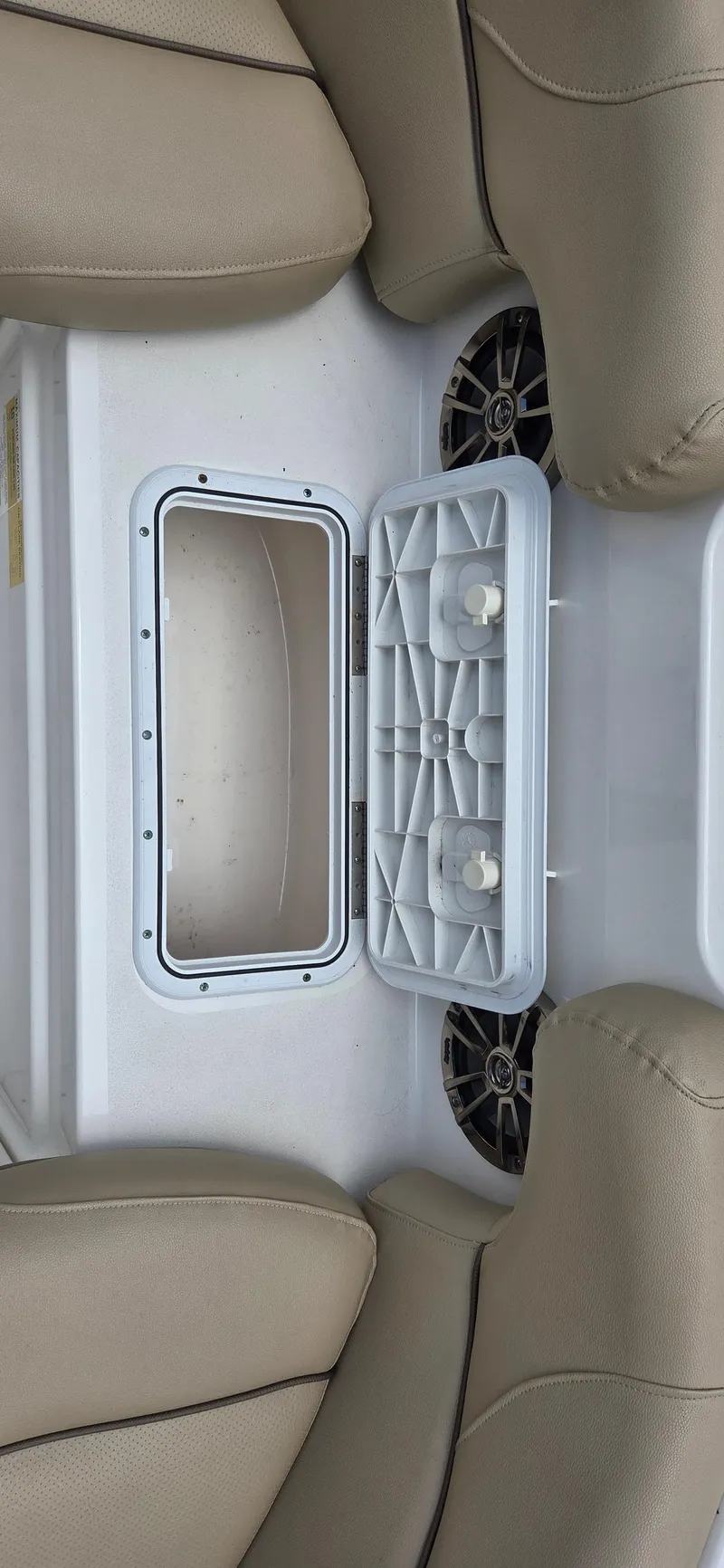 Slide: The Image of 2019 NauticStar 223DC Sport Deck interior storage compartment with beige seating. - 15