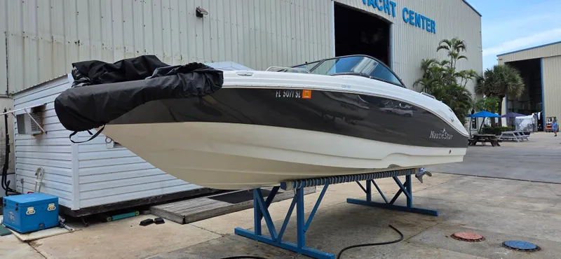 Slide: The Image of 2019 NauticStar 223DC Sport Deck boat on stand at yacht center. - 2