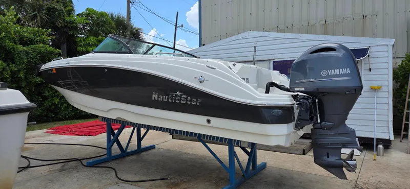 Slide: The Image of 2019 NauticStar 223DC Sport Deck boat with Yamaha outboard motor on a stand. - 3