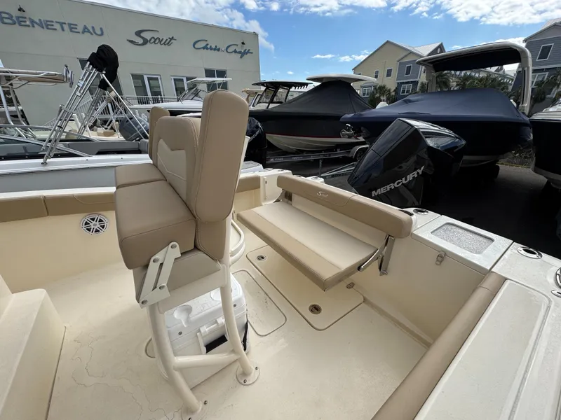 Slide: The Image of 2025 Scout 215 XSF boat interior with seating and Mercury engine, displayed outdoors. - 11