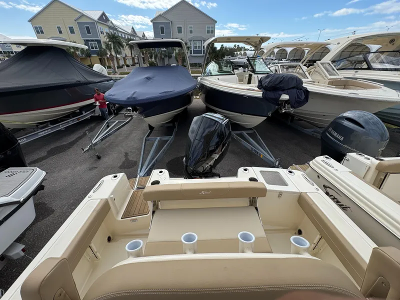 Slide: The Image of 2025 Scout 215 XSF boat in marina, surrounded by other boats. - 13