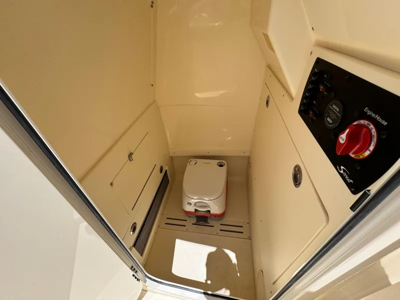 Slide: The Image of 2025 Scout 215 XSF boat interior with compact marine toilet and control panel. - 14