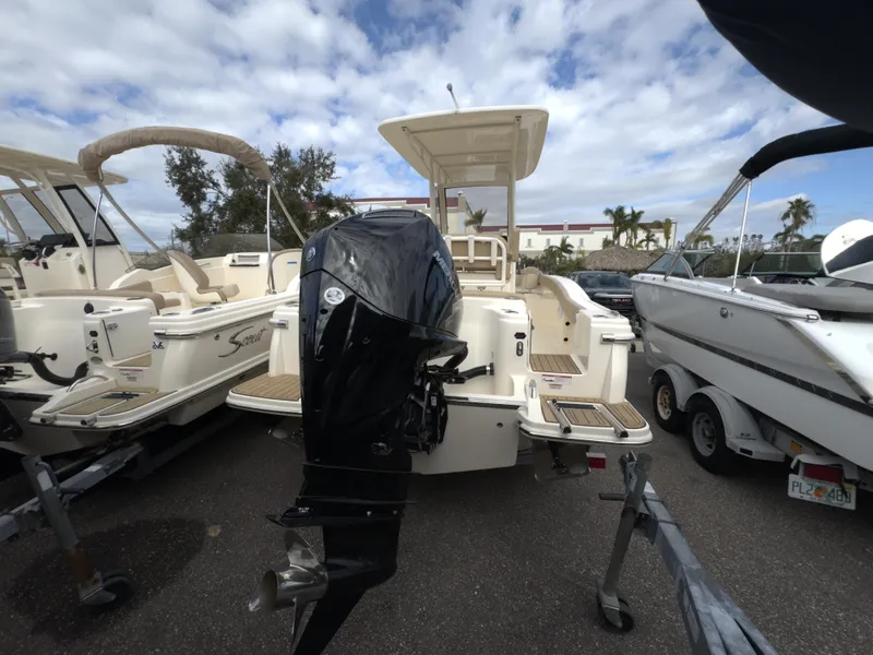 Slide: The Image of 2025 Scout 215 XSF boat with outboard motor, parked in a marina. - 3