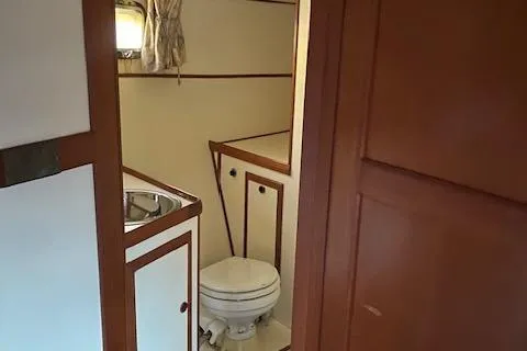 Slide: The Image of 1984 Nova Trawler Heritage bathroom with sink, toilet, and wooden cabinetry. - 12