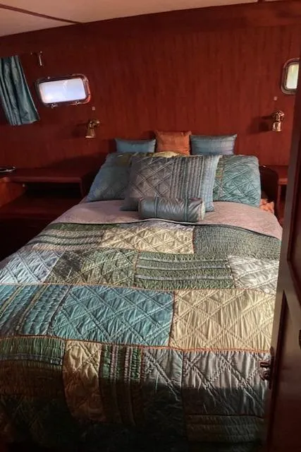 Slide: The Image of Cozy bedroom in 1984 Nova Trawler Heritage with patchwork quilt and wooden interior. - 18