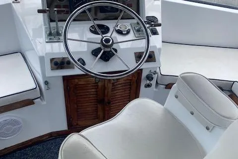 Slide: The Image of 1984 Nova Trawler Heritage boat helm with steering wheel and white seating. - 4