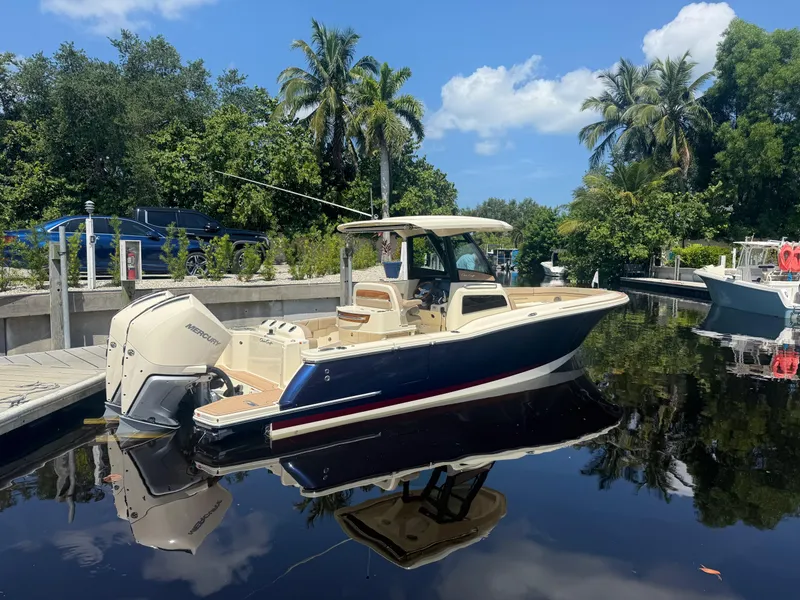Slide: The Image of 2025 Chris-Craft Catalina 28 boat docked on a sunny day, surrounded by lush greenery. - 11