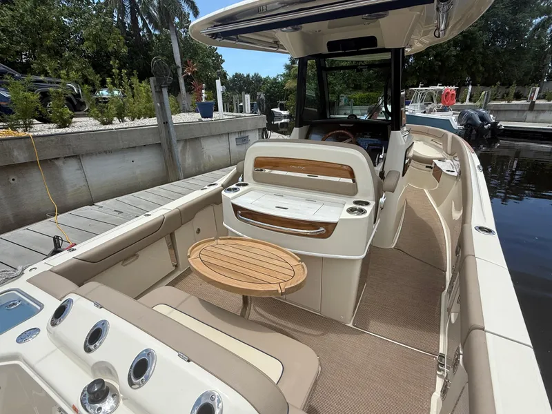 Slide: The Image of 2025 Chris-Craft Catalina 28 boat interior with seating and wooden table at dock. - 15