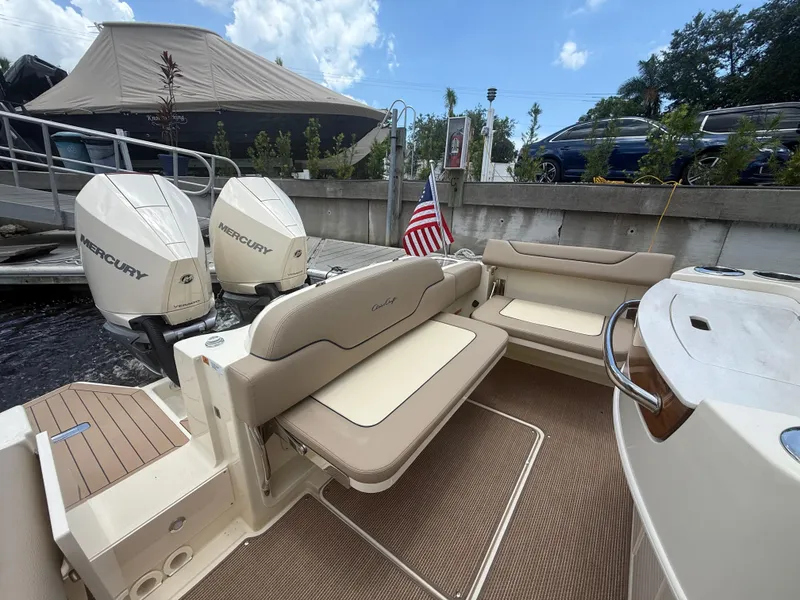 Slide: The Image of 2025 Chris-Craft Catalina 28 boat with twin Mercury engines, docked with seating area. - 17