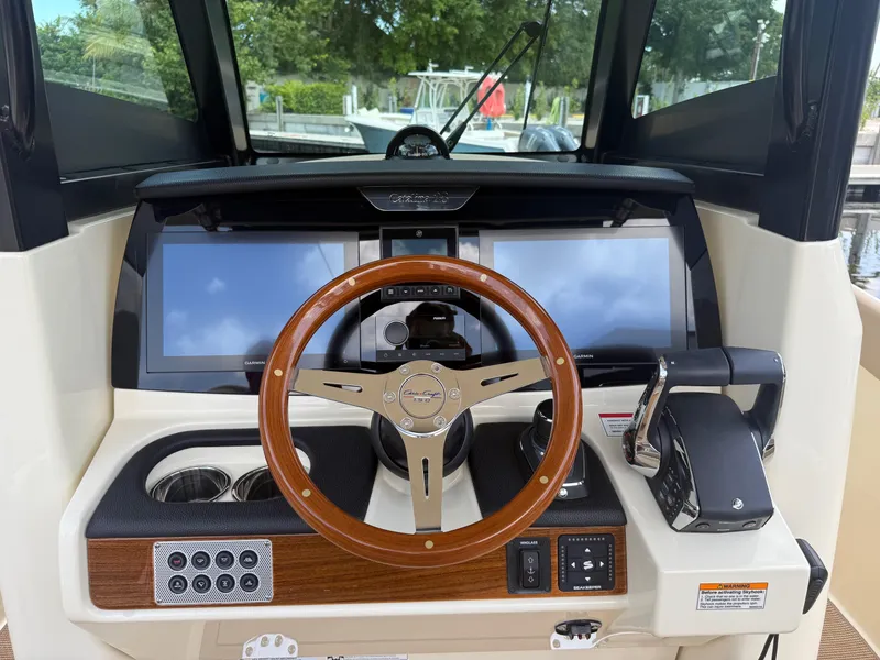 Slide: The Image of 2025 Chris-Craft Catalina 28 helm with wooden steering wheel and modern navigation displays. - 24