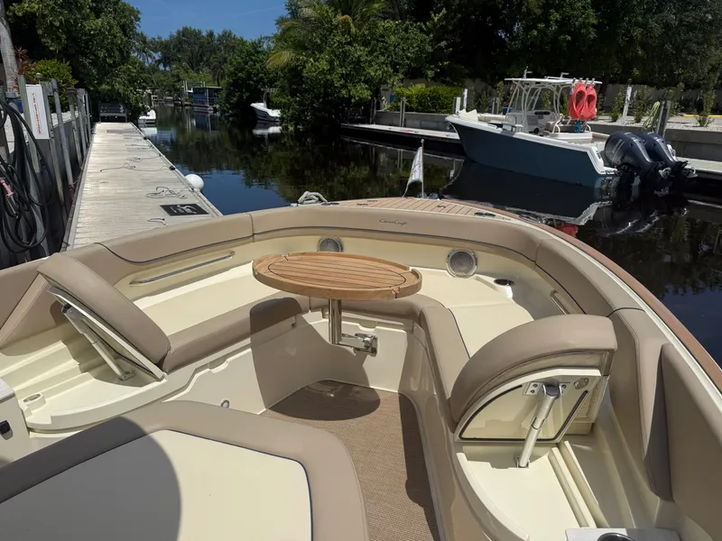 Slide: The Image of 2025 Chris-Craft Catalina 28 boat interior with seating and table, docked by a serene waterway. - 31