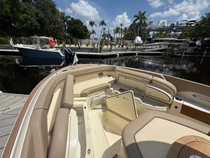 Slide: The Image of 2025 Chris-Craft Catalina 28 boat interior at a marina, featuring luxurious seating and storage. - 32