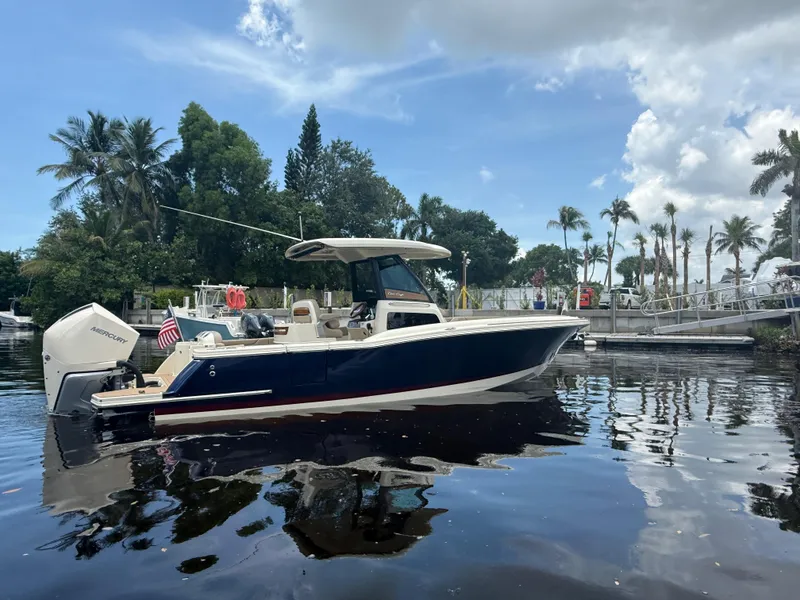 Slide: The Image of 2025 Chris-Craft Catalina 28 boat on calm water, surrounded by palm trees. - 4