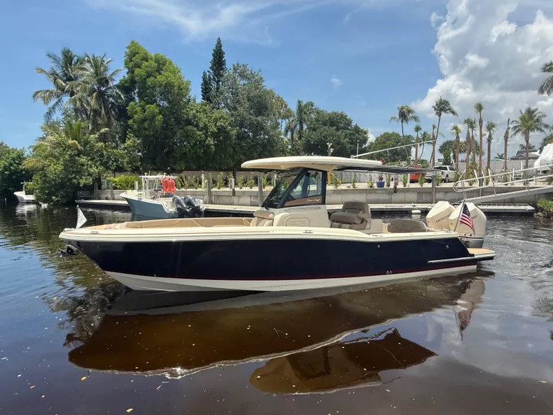 Slide: The Image of 2025 Chris-Craft Catalina 28 boat on calm water, surrounded by lush greenery. - 7