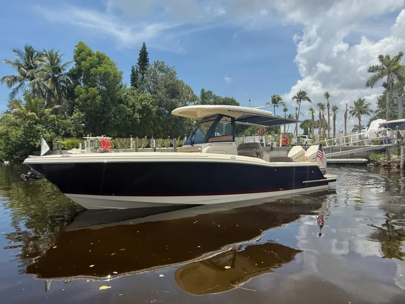 Slide: The Image of 2025 Chris-Craft Catalina 28 boat on calm water, surrounded by lush greenery and palm trees. - 8