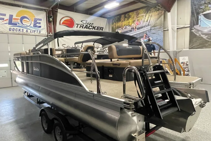 Slide: The Image of 2026 Barletta Cabrio 24UE pontoon boat displayed in a showroom with banners. - 3