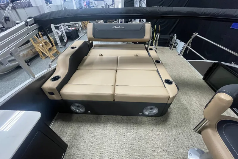 Slide: The Image of 2026 Barletta Cabrio 24UE boat interior with beige seating and cup holders. - 6