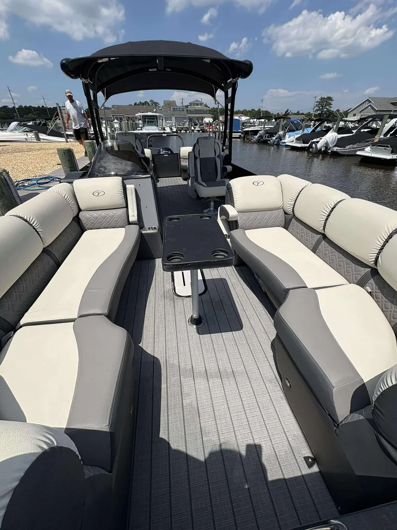 Slide: The Image of 2023 Veranda V25RCT pontoon boat with spacious seating and sleek design at a marina. - 5
