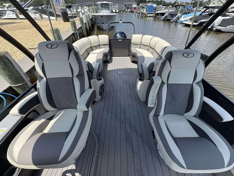 Slide: The Image of 2023 Veranda V25RCT pontoon boat interior with luxurious seating and modern design at a marina. - 6