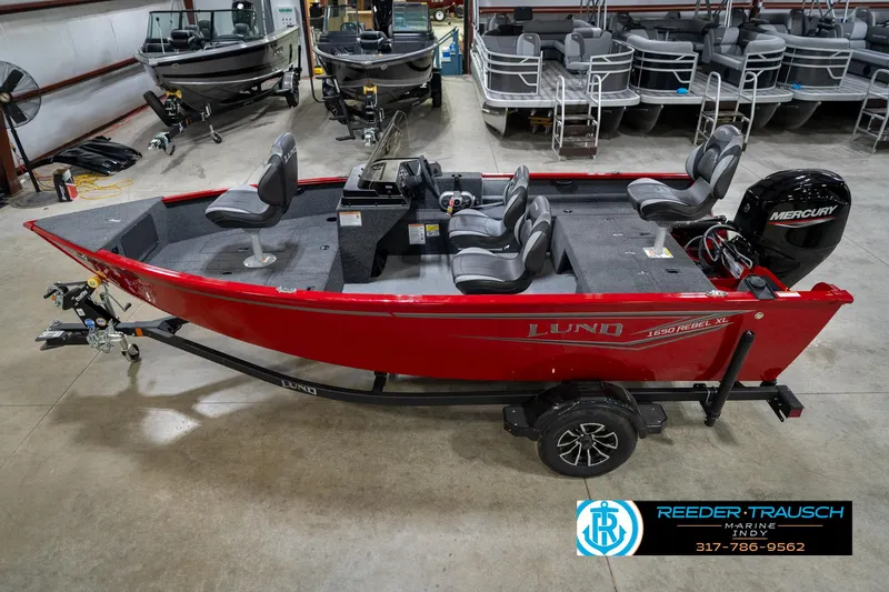 The Image of 2026 Lund 1650 Rebel XL SS boat in showroom, red exterior, Mercury engine, trailer included. - 1