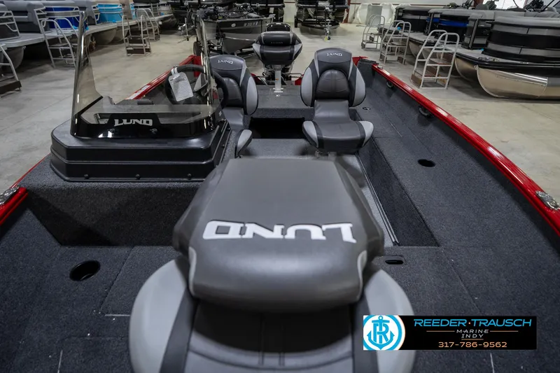 Slide: The Image of 2026 Lund 1650 Rebel XL SS boat interior with seating and console, displayed in a showroom. - 17