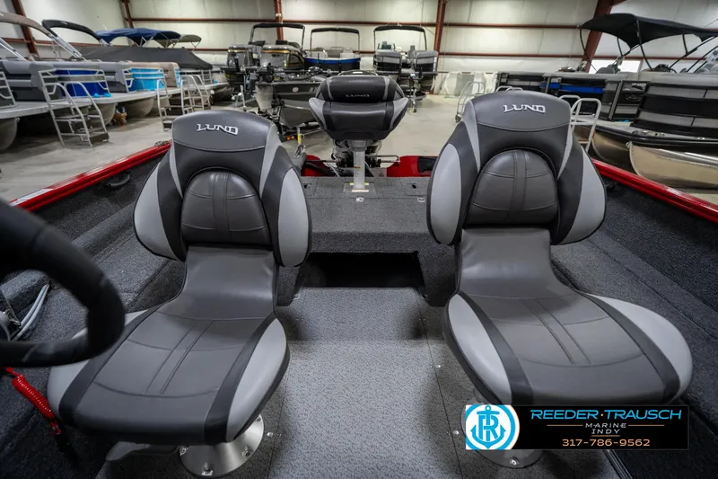 Slide: The Image of 2026 Lund 1650 Rebel XL SS boat interior with two gray seats in a showroom. - 18