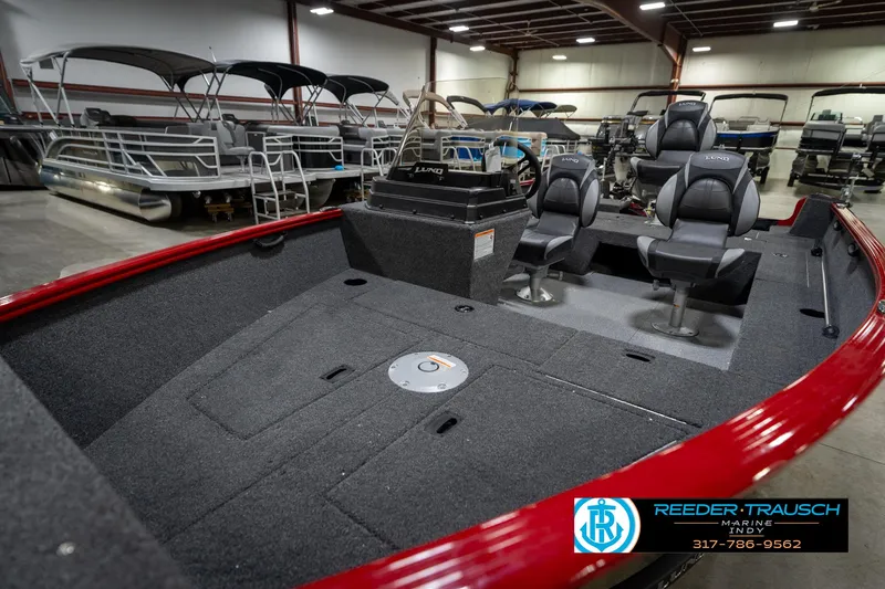 Slide: The Image of 2026 Lund 1650 Rebel XL SS boat interior with seating, displayed in a showroom. - 21