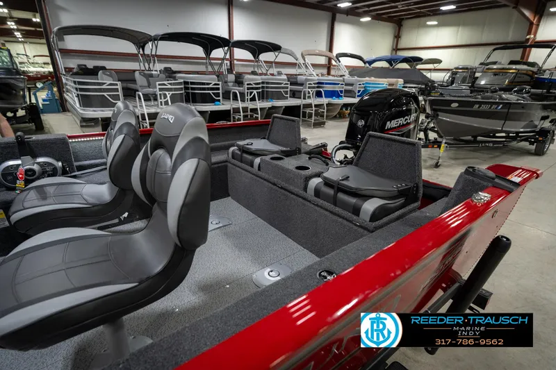 Slide: The Image of 2026 Lund 1650 Rebel XL SS boat interior with seating and Mercury engine in showroom. - 29