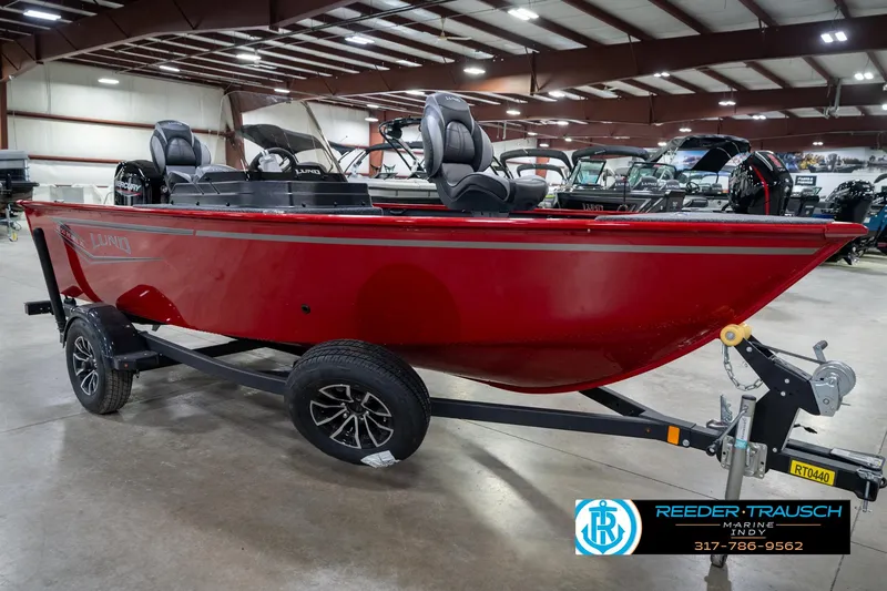Slide: The Image of 2026 Lund 1650 Rebel XL SS boat in showroom, red exterior, on trailer. - 4