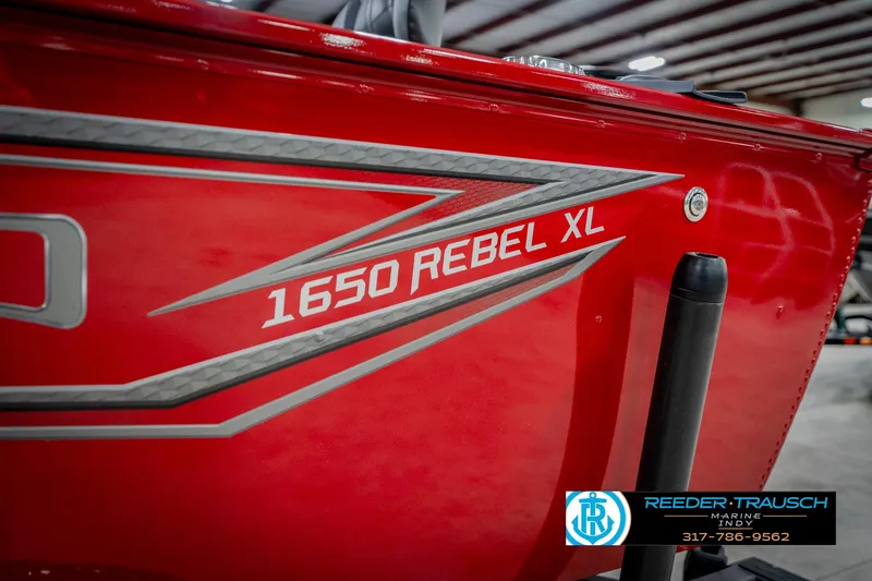 Slide: The Image of 2026 Lund 1650 Rebel XL SS boat in vibrant red, showcased indoors. - 56