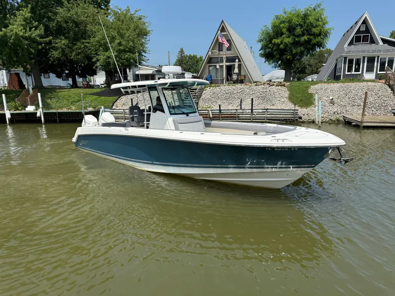 Slide: The Image of 2024 Boston Whaler 330 Outrage boat docked near waterfront homes. - 2