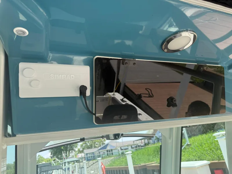 Slide: The Image of 2024 Boston Whaler 330 Outrage dashboard with Simrad electronics and sleek blue finish. - 20