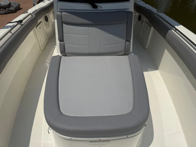 Slide: The Image of 2024 Boston Whaler 330 Outrage boat interior with gray cushioned seating. - 21