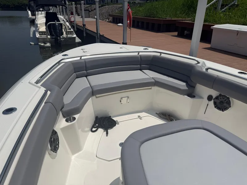 Slide: The Image of 2024 Boston Whaler 330 Outrage boat interior with cushioned seating and docked at marina. - 22