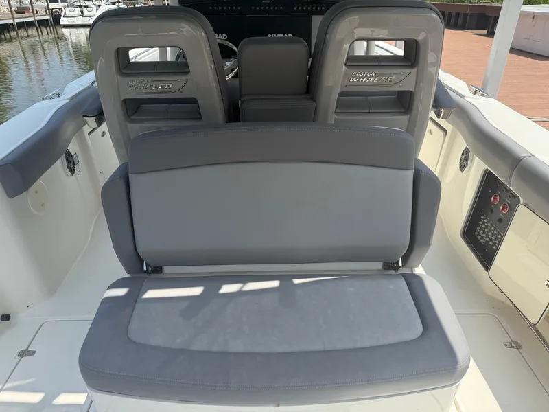 Slide: The Image of 2024 Boston Whaler 330 Outrage boat seating area with gray cushions. - 28