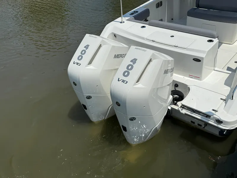 Slide: The Image of 2024 Boston Whaler 330 Outrage with twin Mercury 400 V10 engines in water. - 7