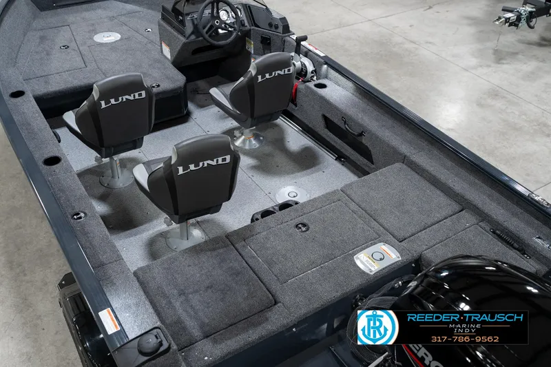 Slide: The Image of 2026 Lund 1775 Adventure SS boat interior with seating and steering console, displayed at Reeder Trausch Marine. - 13